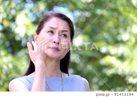 強い日差しの公園で体調不良のシニア女性 91453194