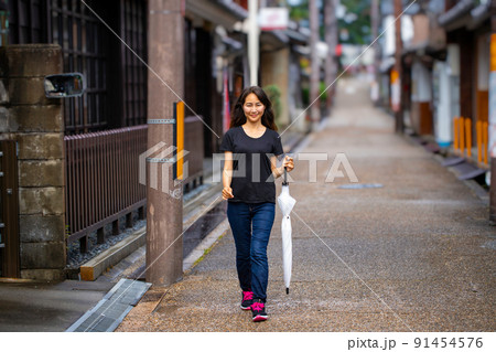 雨上がりの街を散歩する女性の写真素材 [91454576] - PIXTA