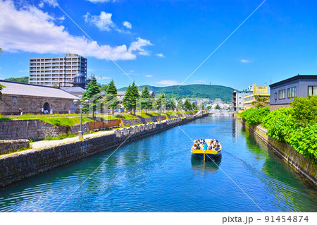 新緑の北海道小樽市、中央橋から見る快晴の北側の小樽運河の街並みと運河クルーズ船 91454874