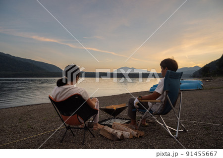 夕焼けを見ながら焚き火をするカップル 夕焼けを見ながら焚き火をするカップル 91455667