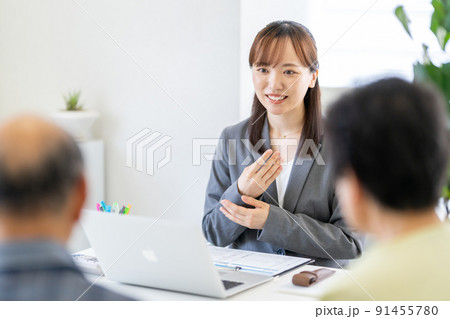 老夫婦の相談を親身になって聞く女性　営業　遺言　相続　遺留分　生前贈与　接客 91455780