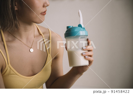 プロテインを飲む若い女性 91458422