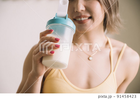 プロテインを飲む若い女性 91458423