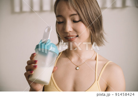プロテインを飲む若い女性 91458424