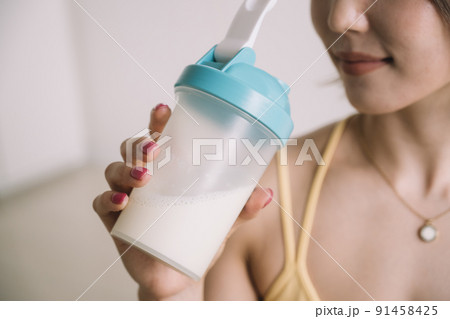 プロテインを飲む若い女性 91458425