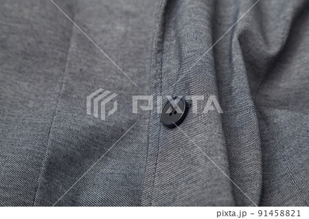 details and quality shot of formal black or dark grey wool suit fabric texture. with button decoration under light and shadow ambient. details and quality shot of formal black or dark grey wool suit fabric texture. with button decoration under light and shadow ambient. 91458821