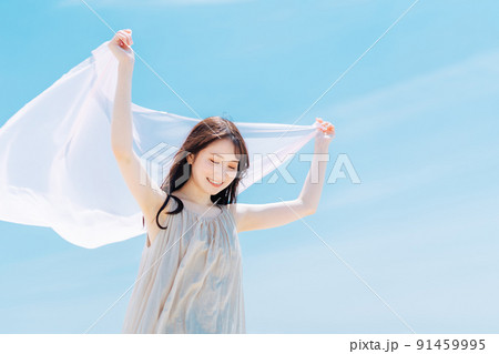 青空背景の女性ポートレート 91459995