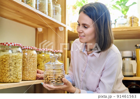 Young woman in kitchen with containers jars of food 91461563