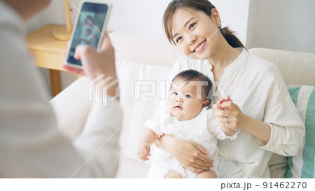 スマホで赤ちゃんを撮影するカップル 91462270