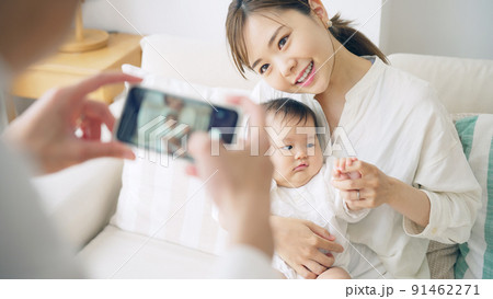 スマホで赤ちゃんを撮影するカップル 91462271