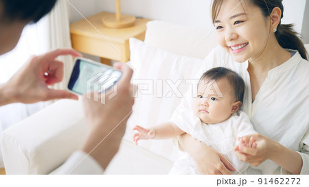 スマホで赤ちゃんを撮影するカップル 91462272