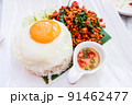 Rice topped with stir-fried pork and basil and a fried egg 91462477