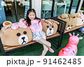 Closeup Asia little girl pose with bear on chair 91462485