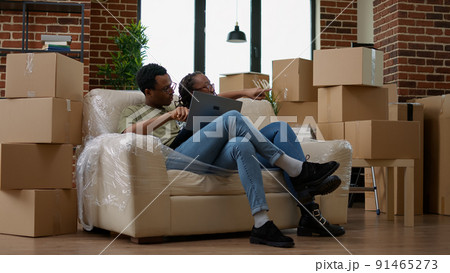 Married couple buying furniture online on laptop to decorate new house, moving in together. Doing online shopping for interior decoration after relocation, rented apartment flat. 91465273