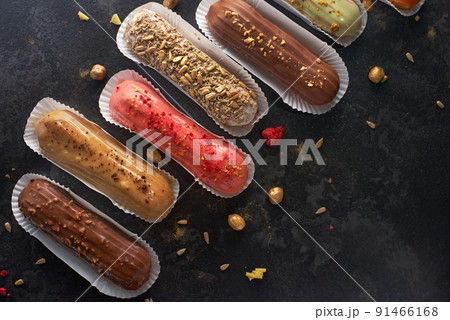 Traditional French dessert. Assorted eclairs on a dark stone background. flat lay, banner Traditional French dessert. Assorted eclairs on a dark stone background. flat lay, banner 91466168