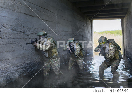Three military mercenaries during special operation in underground bunker. Collage - one model in three poses. Three military mercenaries during special operation in underground bunker. Collage - one model in three poses. 91466340
