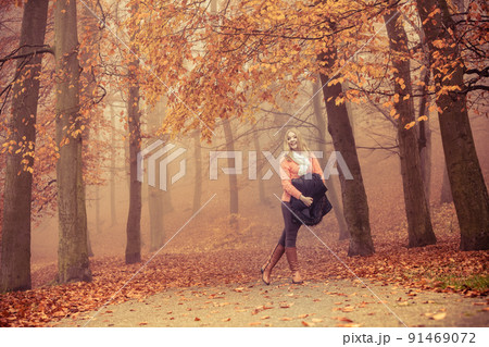 Smiling fashion blonde woman with jacket in park. Smiling fashion blonde woman with jacket in park. 91469072