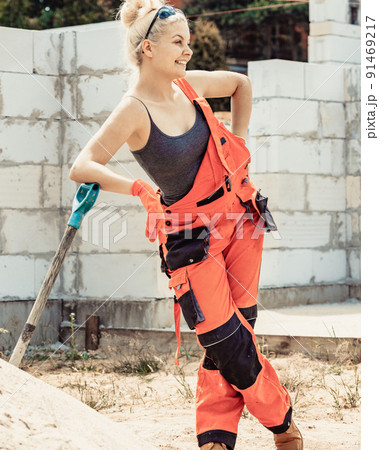 Woman using shovel on constriction site 91469217