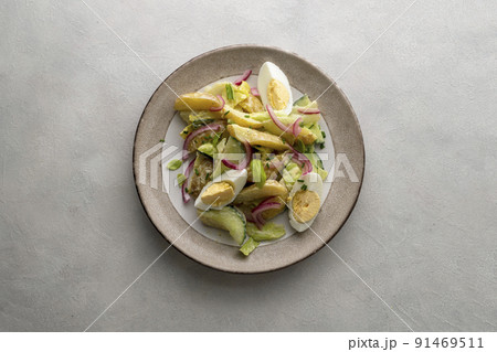 Potato salad with eggs, cucumbers, cabbage and red pickled onions. Delicious healthy summer salad. Potato salad with eggs, cucumbers, cabbage and red pickled onions. Delicious healthy summer salad. 91469511