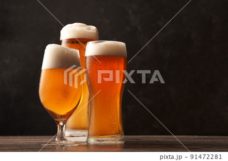 Three different glasses of beer on black background. Three different glasses of beer on black background. 91472281