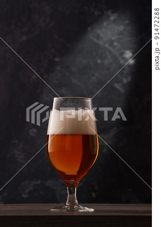 Tulip glass of beer on black background. Tulip glass of beer on black background. 91472288