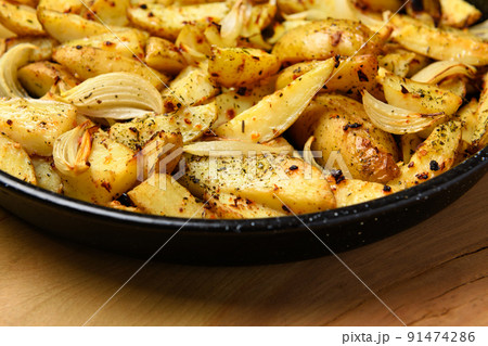 roasted potatoes in a frying pan, cooked food, delicious crust, one object on a wooden background roasted potatoes in a frying pan, cooked food, delicious crust, one object on a wooden background 91474286