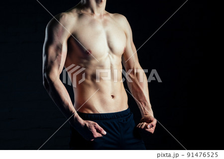torso of young man posing without shirt in the gym 91476525