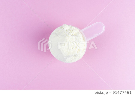 Vanilla protein powder scoop on pink background. Female sport supplements, weight loss powder, plant based, pea powder, organic casein isolate 91477461