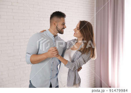 Lovely young couple dancing together at home Lovely young couple dancing together at home 91479984