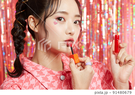 シールメイクをした若い女性のキラキラ背景のビューティーポートレート 91480679