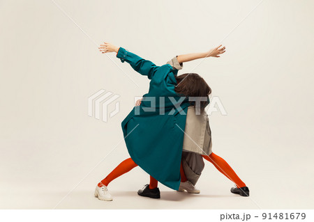Portrait of stylish man and woman in coats and tights posing isolated over grey studio background 91481679