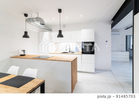 Modern kitchen with a dining area and a counter. 91485703