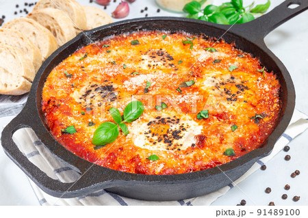 Shakshuka with eggs, Italian sausage, tomato sauce, in cast iron pan, horizontal Shakshuka with eggs, Italian sausage, tomato sauce, in cast iron pan, horizontal 91489100