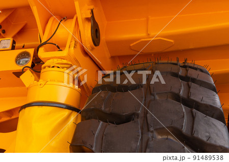 Huge rear wheels of dump truck at unusual angle closeup. 91489538