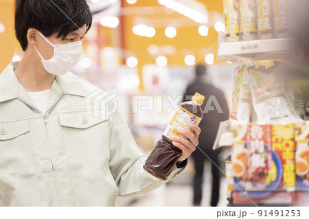 スーパーで買い物をするマスク姿の作業服男性 91491253