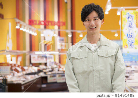 スーパーで買い物をする作業服姿の若い男性 91491488