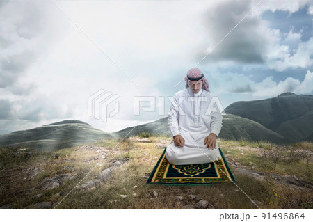 Muslim man with keffiyeh with agal in praying position (salat) on the prayer rug 91496864
