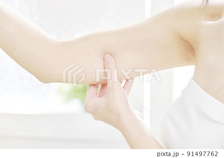 二の腕を摘む女性のクローズアップ 91497762