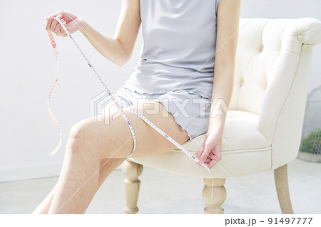 リビングでメジャーで太ももを測る女性 顔無し リビングでメジャーで太ももを測る女性 顔無し 91497777