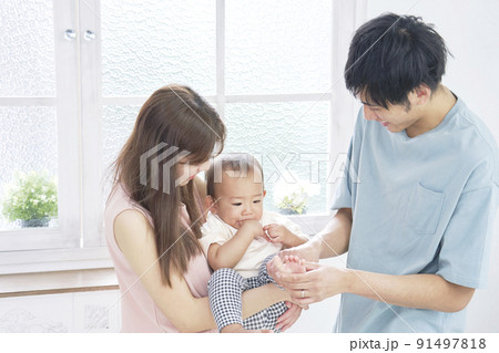 リビングで赤ちゃんと遊ぶ夫婦 リビングで赤ちゃんと遊ぶ夫婦 91497818