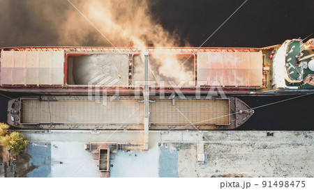 Top view from drone of a large ship loading grain for export. Water transport 91498475