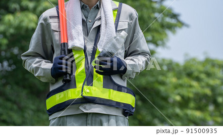 ペットボトルの水を持つ警備員の男性｜建設業・警備業の熱中症対策イメージ 91500935