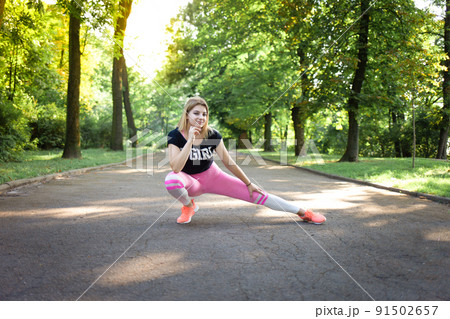 Young sexy girl doing stretching. Fitness woman training in the park 91502657