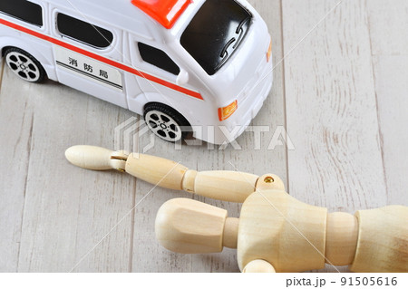 床に倒れている人形と救急車 91505616