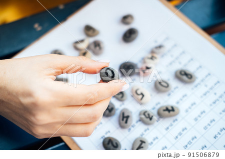 Woman numerologist hand with pebble stone with number zero 0 Woman numerologist hand with pebble stone with number zero 0 91506879