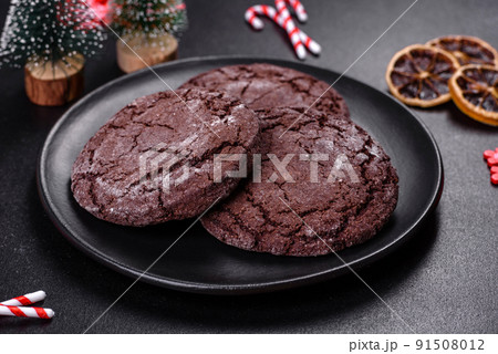 Delicious fresh chocolate biscuits on a dark concrete background with Christmas toys 91508012