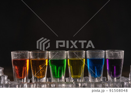 Shots with multicolored alcohol, standing in a row Shots with multicolored alcohol, standing in a row 91508048