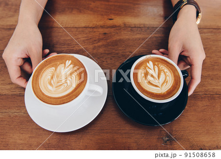 View of couple cup of hot latte coffee with hot cappuccino coffee serving on the wooden table. 91508658