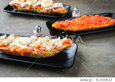 Traditional Spanish breakfast. Tostada with different toppings on a dark background 91509632