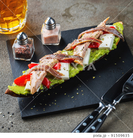 Traditional Spanish breakfast. Tostada with different toppings on a dark background 91509635